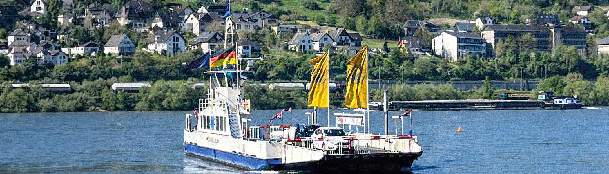 Die Fähre mit einigen Autos auf dem Autodeck ist auf dem Rhein unterwegs
