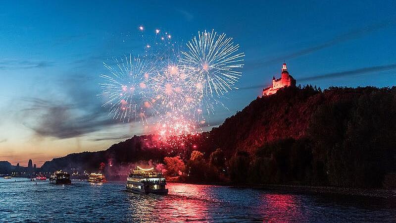 There is a firework over a river, and it is dark.
