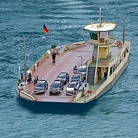 Eine Autofähre ist aus der Vogelperspektive auf einem Gewässer zu sehen.